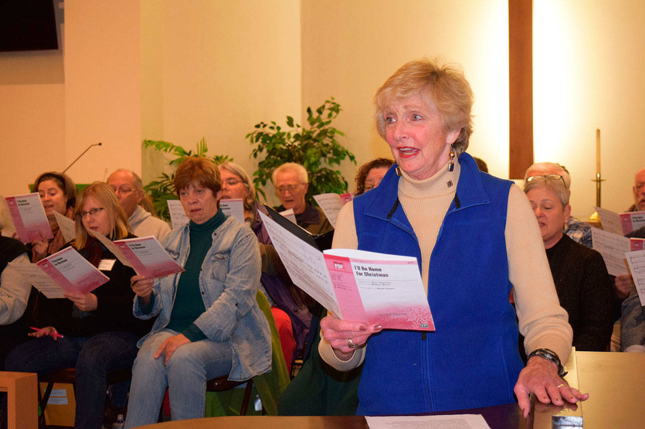 Carol Swarbrick, foreground, and the Peninsula Singers rehearse a variety of holiday songs for the upcoming fall concert “Carols and Carol” set for Saturday and Sunday at Trinity United Methodist Church, 100 S. Blake Ave. (Erin Hawkins/Olympic Peninsula News Group)