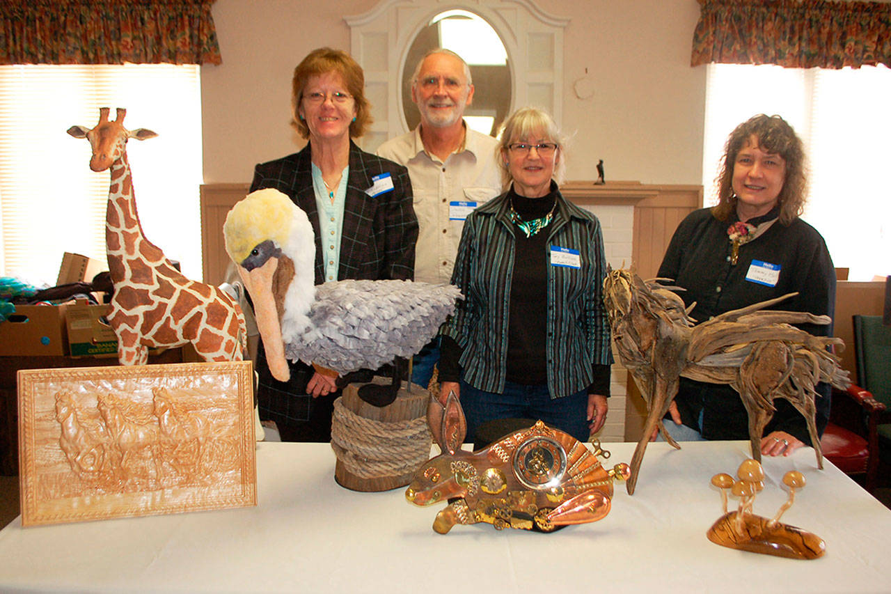 Olympic Theatre Arts sets the stage for “Heart for the Arts” a fundraiser that promotes a variety of artists in the Sequim community. A few of the live auction contributing artists, from left, are Terri Biondolino with “Hank”a pelican sculpture of felt fiber; David Johannessohn; Toy Buillon, with her and her husband Tim’s (not pictured) piece “Rabbit Clock” made from wood and random items; and Tammy Hall with her driftwood sculpture “Pegasus.” (Erin Hawkins/Olympic Peninsula News Group)
