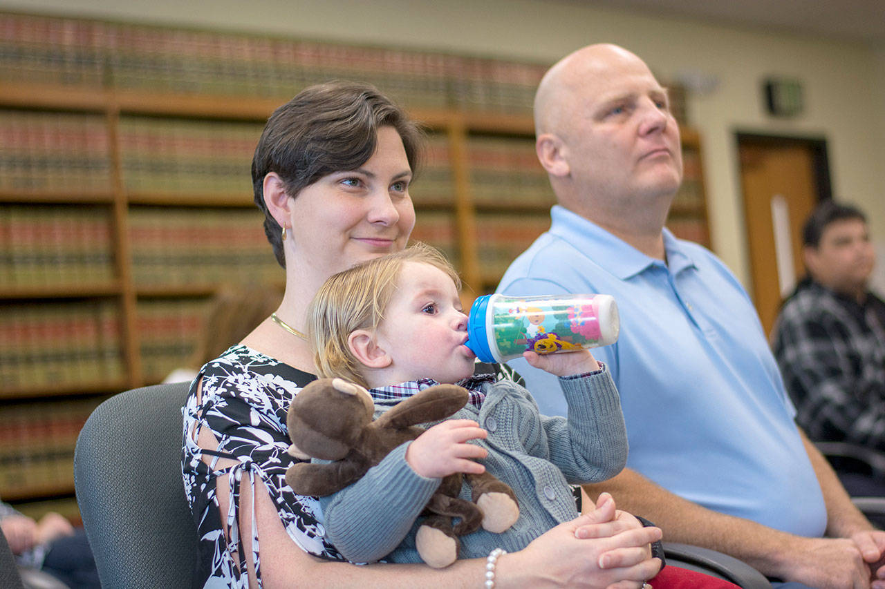 Crystal and Lonnie Bennett watch on during the National Adoption Day ceremony at the Clallam County Courthouse after adopting two-year-old Miles Bennett. (Jesse Major/Peninsula Daily News)