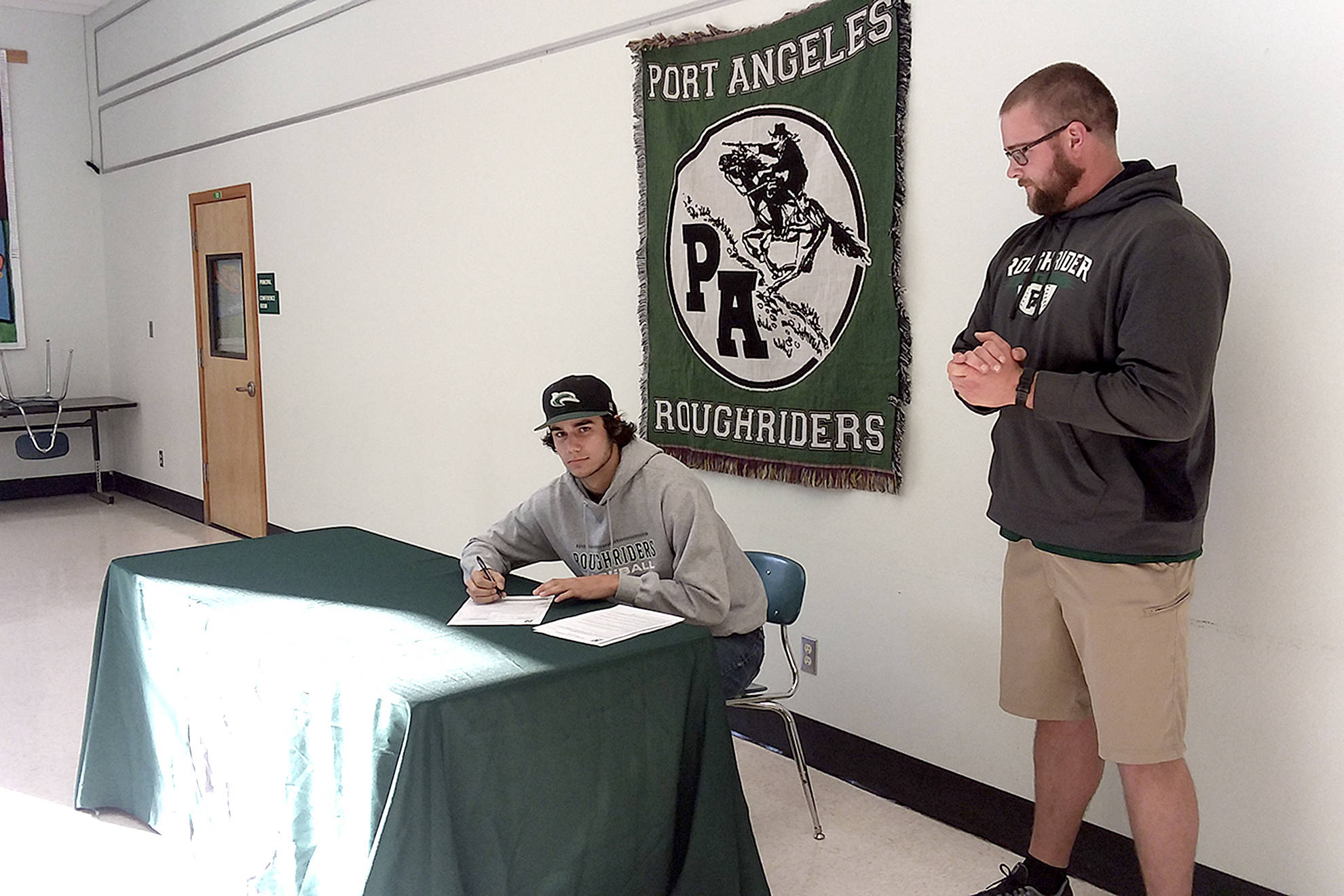 <strong>Pierre LaBossiere</strong>/Peninsula Daily News                                Port Angeles Bo Bradow signs a letter of intent to play baseball for Shoreline College.