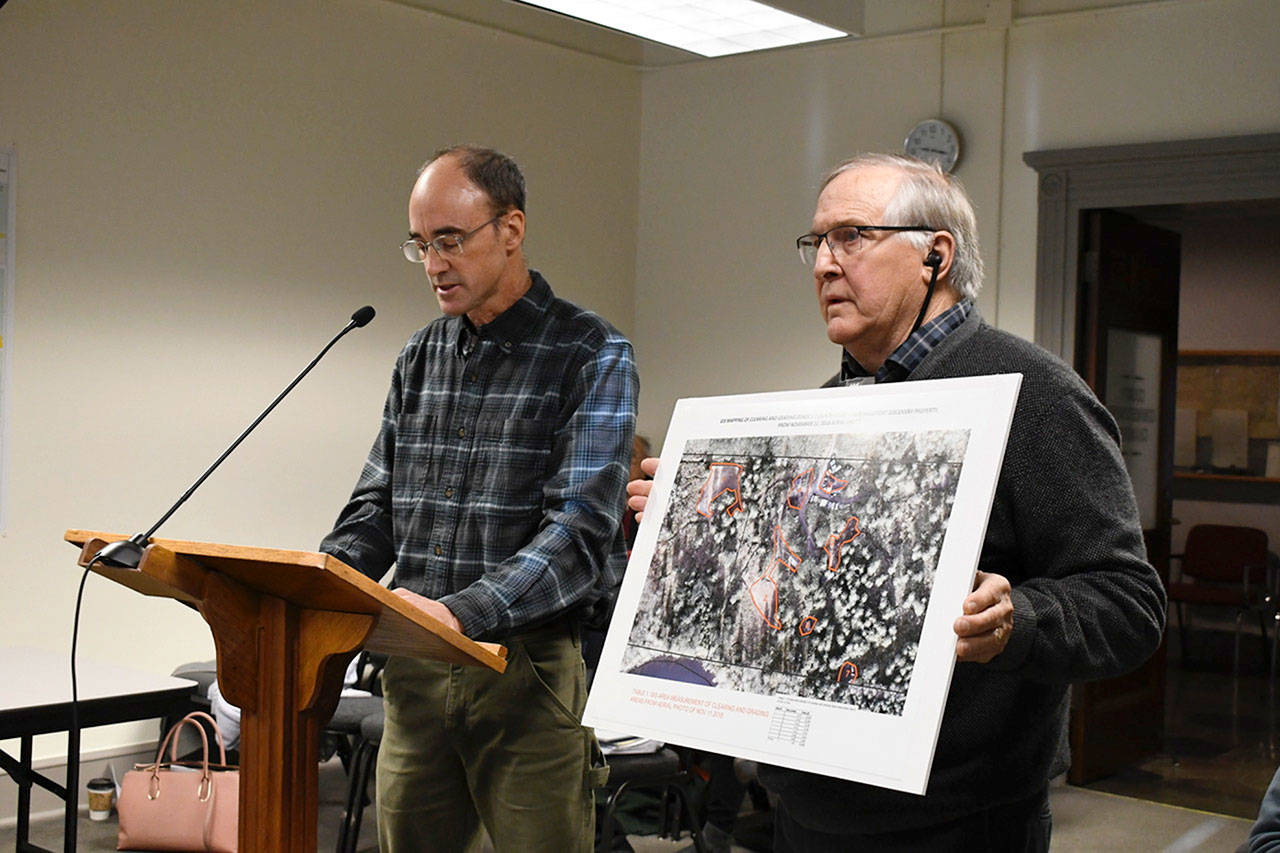 Peter Bales, left, of the Northwest Watershed Institute gave the Jefferson County Commissioners his opinion Monday on the alleged clearing and grading of wetlands on the Tarboo Lake property of Joe D’Amico. Peter Newland of the Tarboo Ridge Coalition holds a photo that was created from drone photography. (Jeannie McMacken/ Peninsula Daily News)