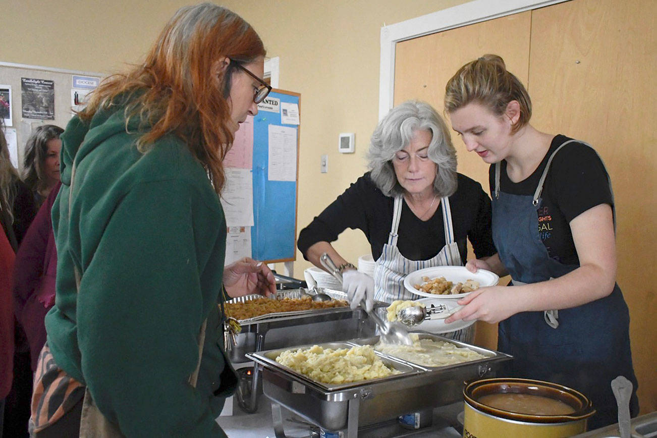 Jeannie McMacken/Peninsula Daily News                                St. Paul’s Episcopal Church in Port Townsend served a record number of meals Wednesday as part of its Wednesday Just Soup program. Volunteers Erica Bauermeister, left, and Anna Wilke served up a full Thanksgiving feast prepared by members of the congregation.