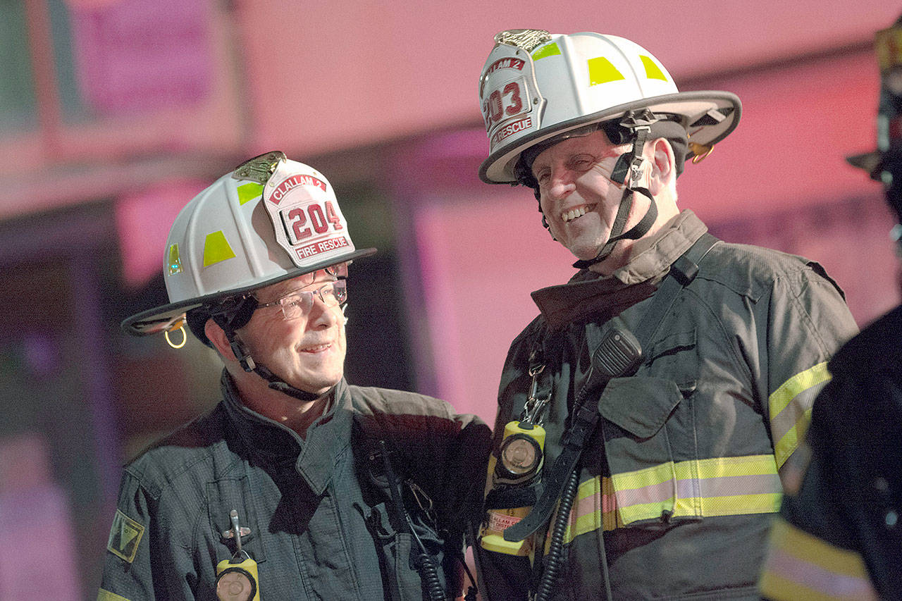 Clallam Fire District No. 2 Assistant Chiefs Mike DeRousie, left, and Dan Huff, talk during a the fire at Sunrise Meats late Saturday night. (Jesse Major/Peninsula Daily News)