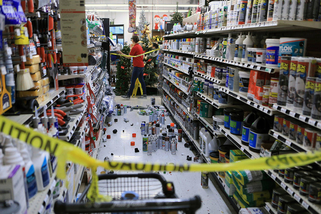 An employee walks past a damaged aisle at Anchorage True Value hardware store after an earthquake, Friday morning in Anchorage, Alaska. (Dan Joling/The Associated Press)