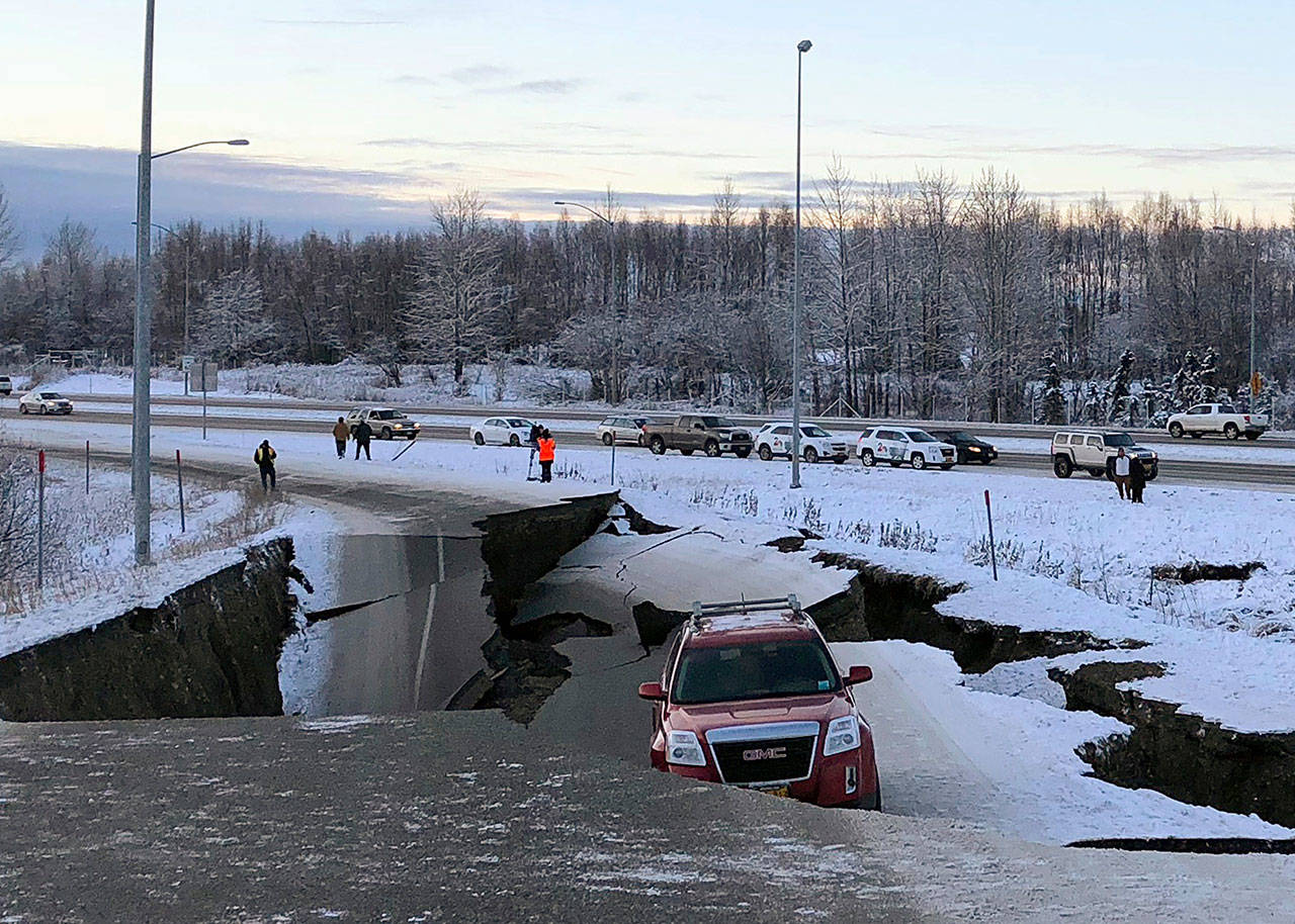 A car is trapped on a collapsed section of the off-ramp of Minnesota Drive in Anchorage on Friday. (Dan Joling/The Associated Press)
