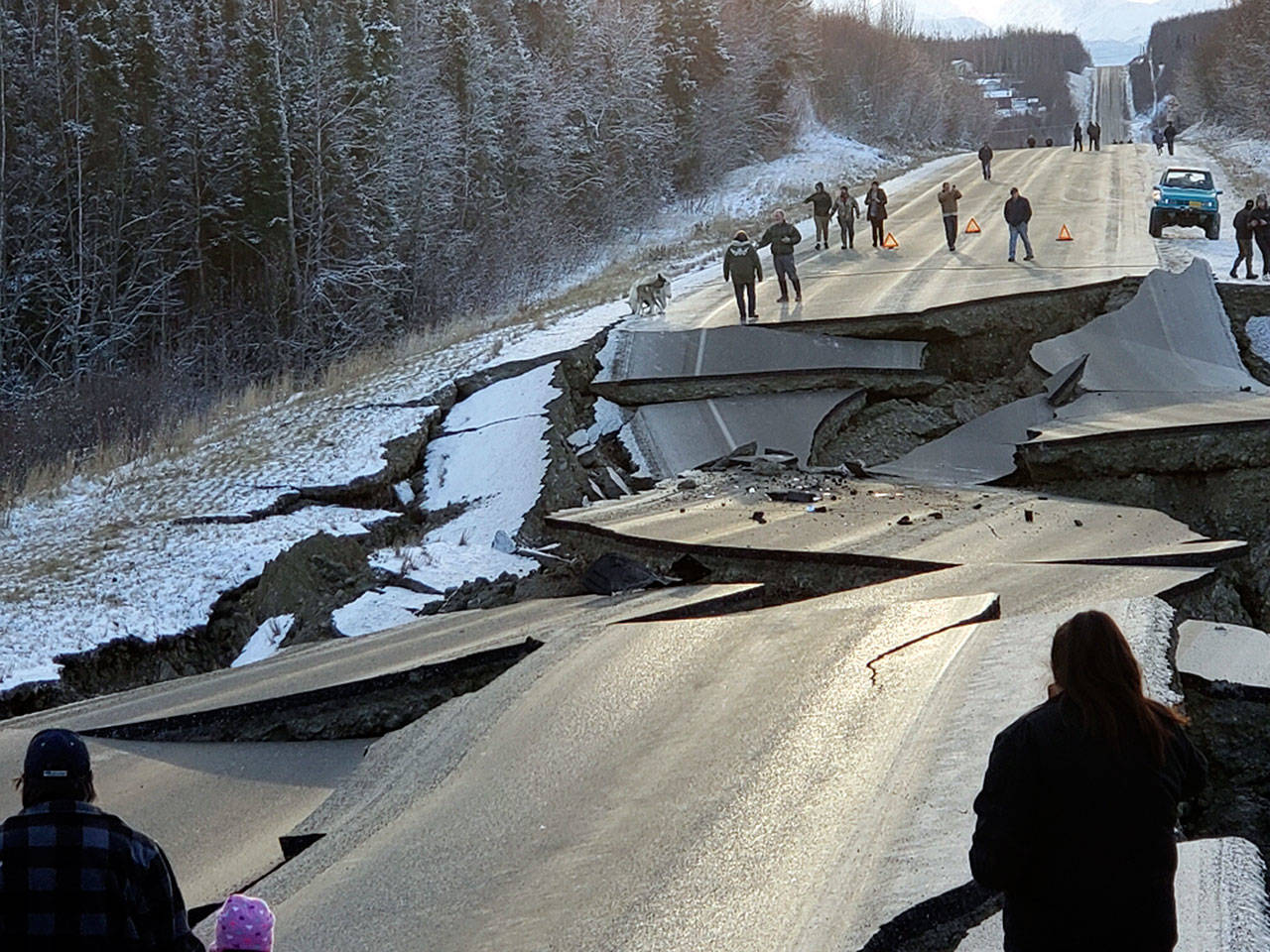 People walk along Vine Road after an earthquake Friday in Wasilla, Alaska. (Jonathan M. Lettow via AP)