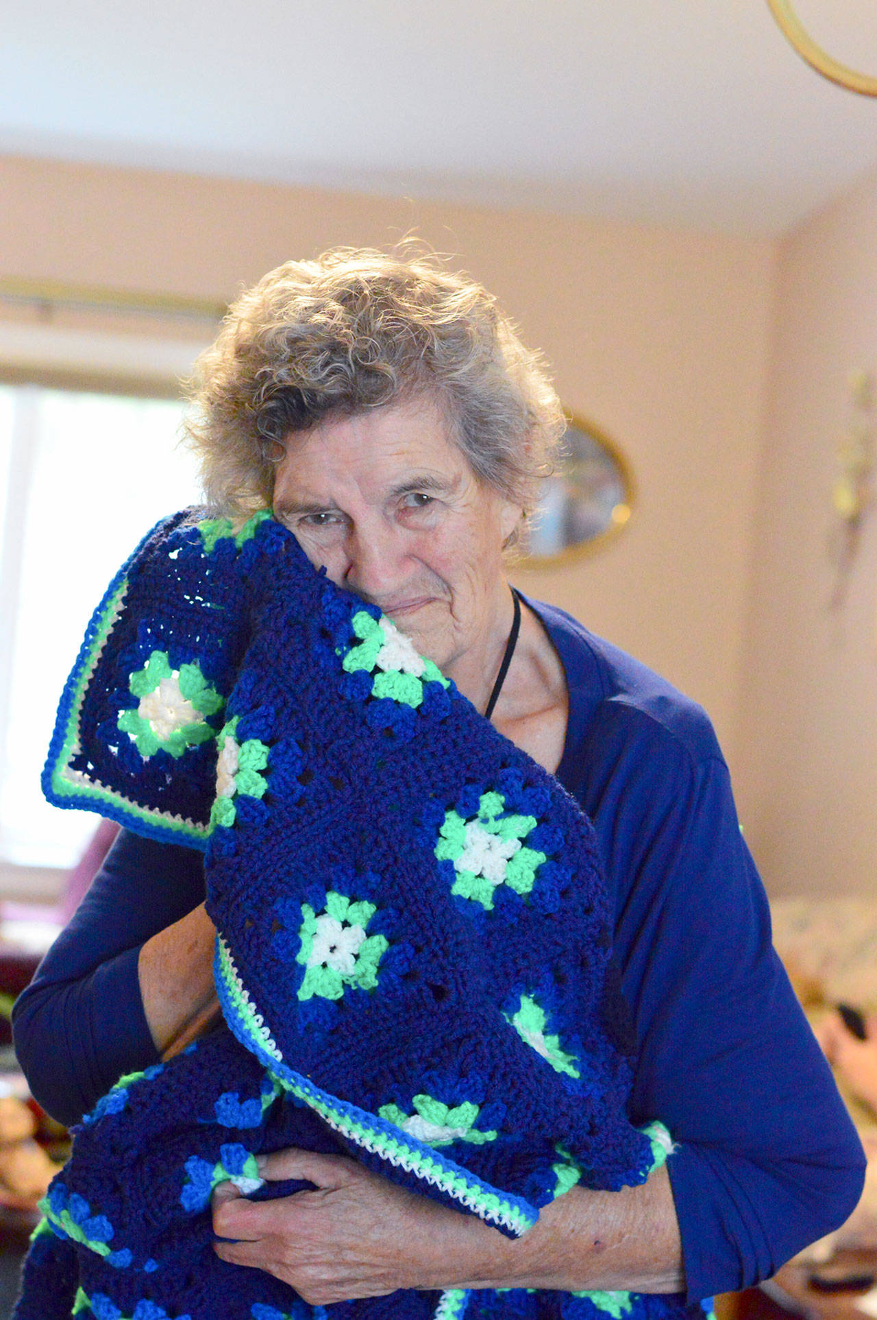 (Diane Urbani de la Paz/for Peninsula Daily News)                                Marie Sewell of Port Townsend makes afghans — such as this one with Seahawks colors — to give away.