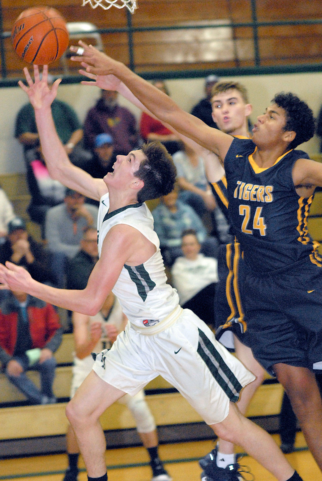 Port Angeles’ Gabriel Long, left, goes for a layup as Burlington-Edison’s Taino Ferdinand defends in the second quarter on Saturday at Port Angeles High School. (Keith Thorpe/Peninsula Daily News)