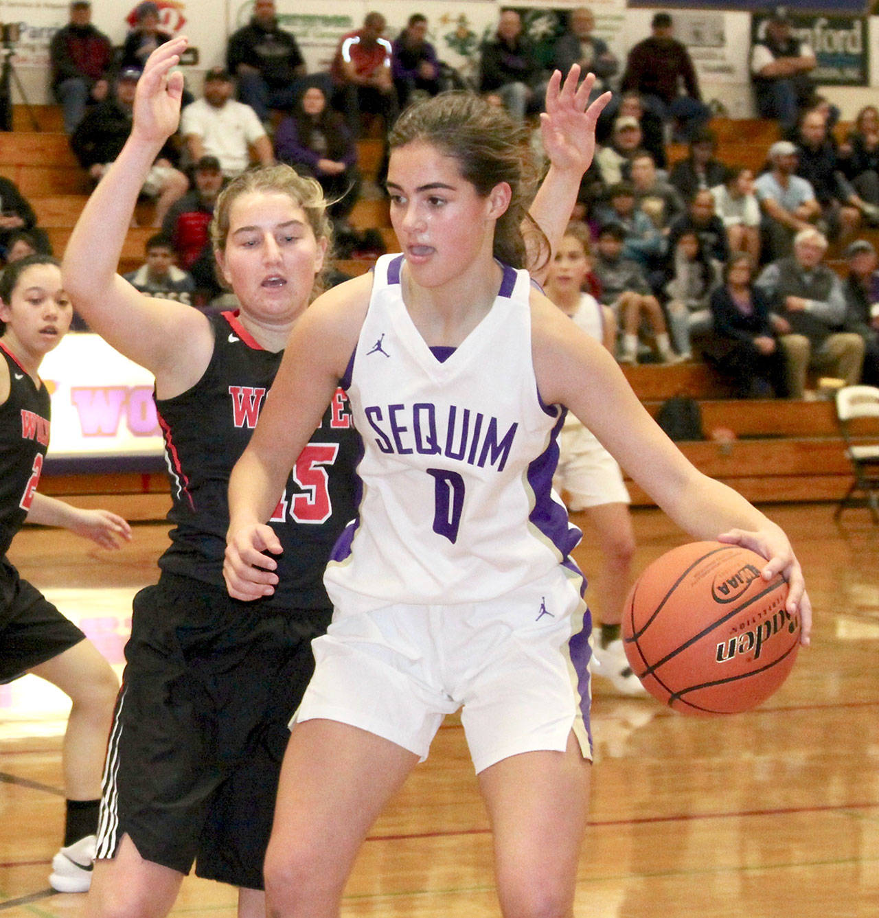 Dave Logan/for Peninsula Daily News Sequim’s Hope Glasser dribbles while defended by Coupeville’s Tia Wurzrainer. The Olympic Peninsula Wolves defeated the Whidbey Island Wolves 50-24.