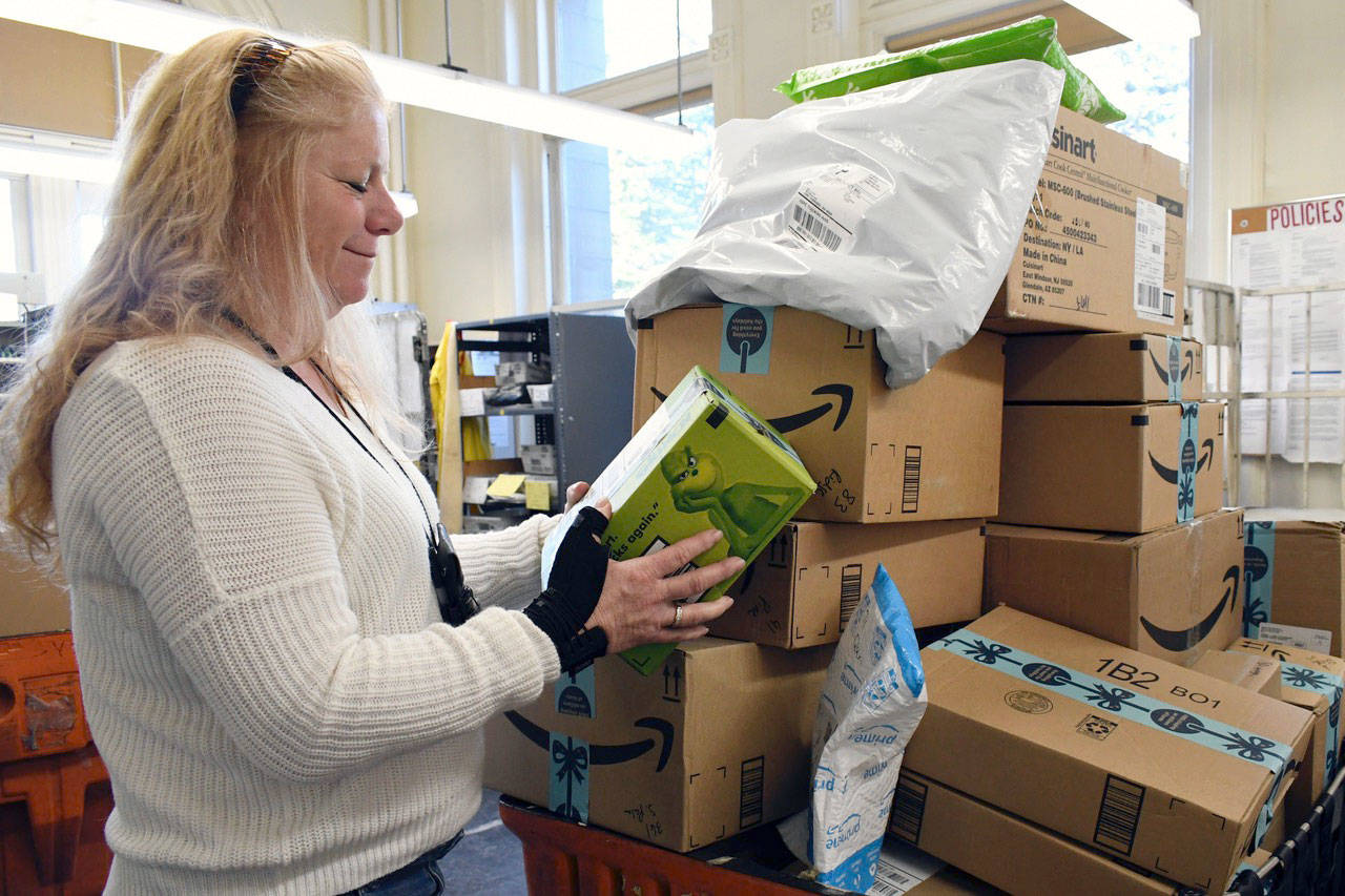 Port Townsend Postmaster Mary Jane Duff checks some packages that were heading out for delivery Thursday. She was promoted to the position after working as acting postmaster since February. Shes been with the agency for 24 years. (Jeannie McMacken/Peninsula Daily News)