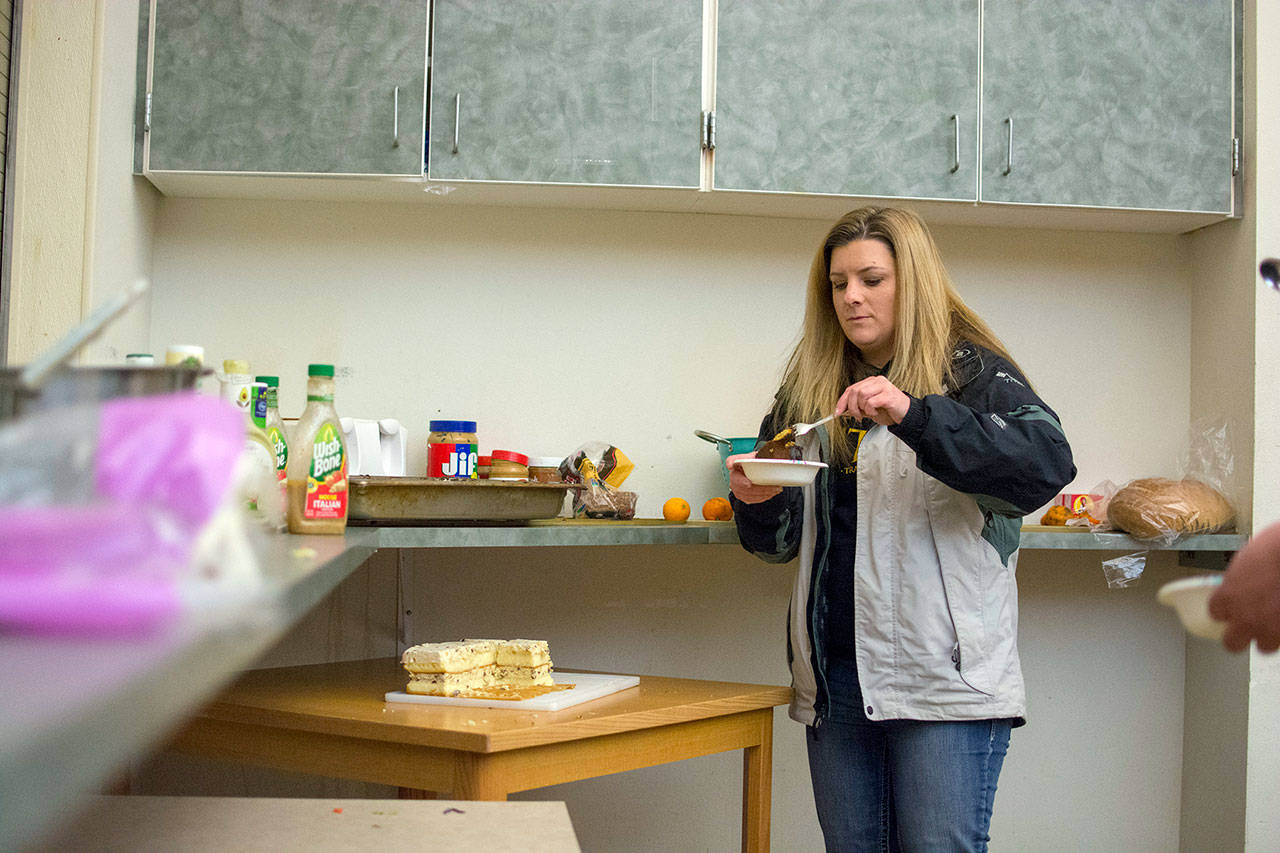 Shenna Younger grabs dessert while staying at Serenity House of Clallam County’s night-by-night shelter Wednesday evening. (Jesse Major/Peninsula Daily News)
