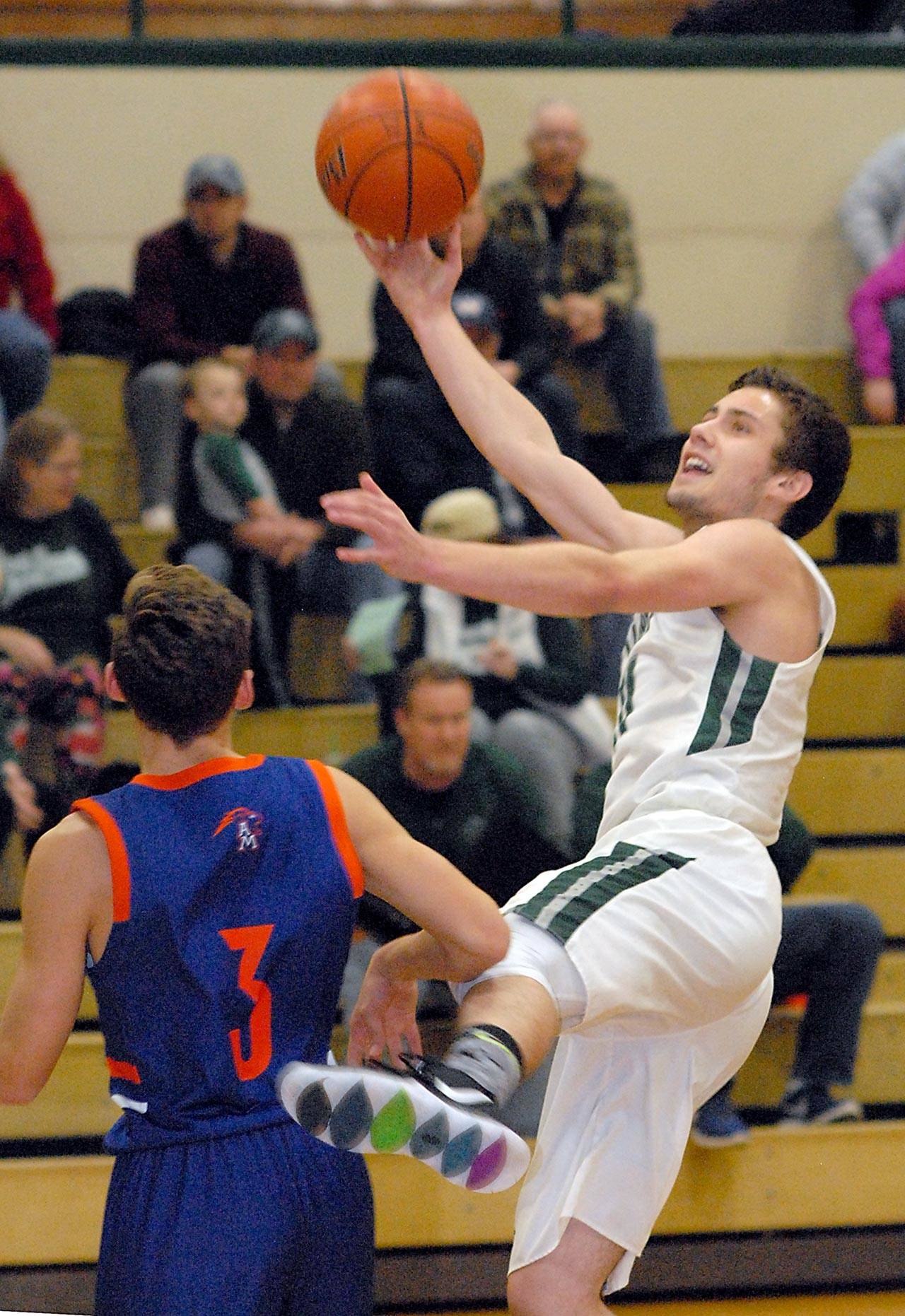 Keith Thorpe/Peninsula Daily News Port Angeles’ Kyle Benedict takes an off-balance layup over the head of Auburn Mountview’s Andrew Rotter in the championship game of the Port Angeles Holiday Tournament on Saturday at Port Angeles High School.