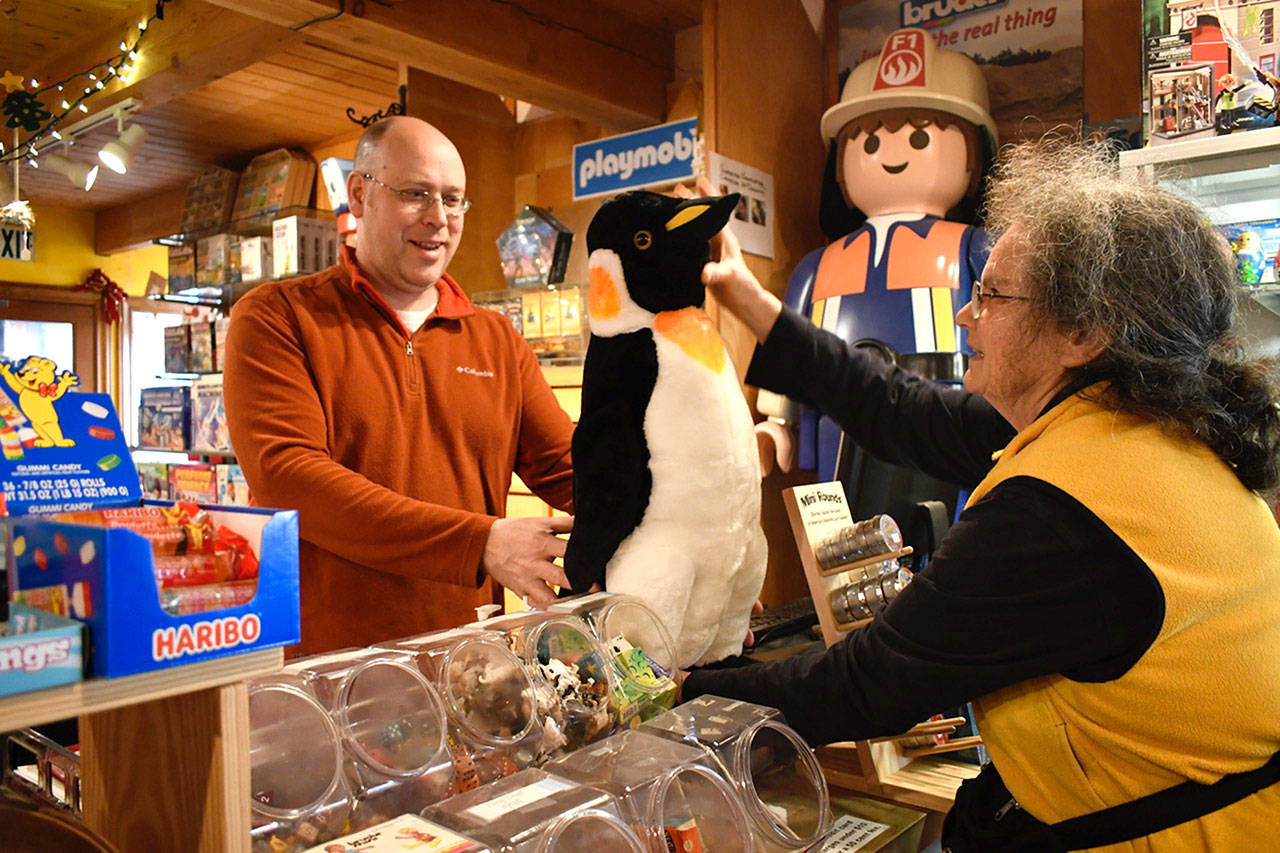 As a special Christmas gift, Pam Gray chose a large stuffed king penguin for her friend’s great niece Titi, age 3. Steve Goldenbogen of Whistle Stop Toys happened to have the toy in stock. Gray said she had been on an expedition and saw a half million king penguins and told Titi about them. Last-minute gifts of all kinds for children were selling well the day before Christmas in Port Townsend. (Jeannie McMacken/Peninsula Daily News)