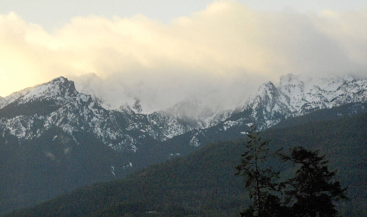 Snow-covered Klahhane Ridge south of Port Angeles plays peek-a-boo with a bank of clouds. (Keith Thorpe/Peninsula Daily News)