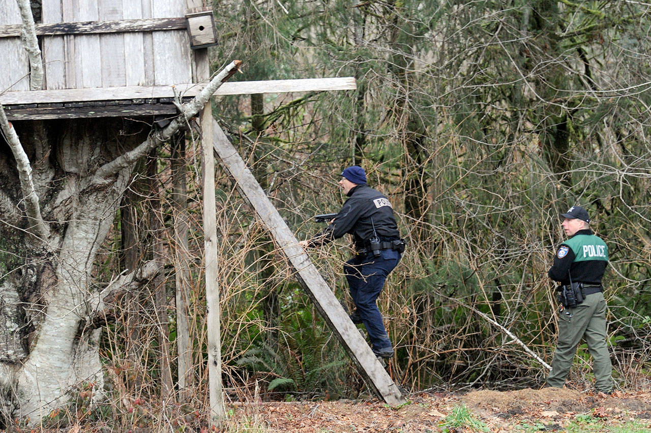 Law enforcement officers search a treehouse near Lake Pleasant Park where the driver of a car who was pursued in a high-speed chase fled the scene. (Lonnie Archibald/For Peninsula Daily News)