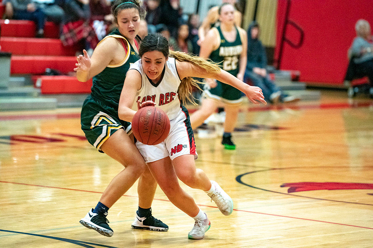 Steve Mullensky/for Peninsula Daily News Neah Bay’s Courtney Swan blasts past Auburn’s Jacklynn Smith and charges for the basket during a Crush in the Slush game in Port Townsend on Friday. Swan led the Red Devils with 19 points.