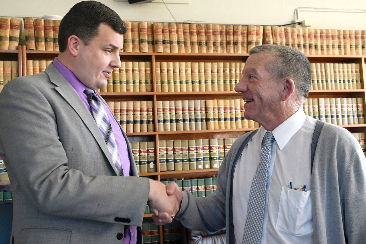 Jefferson County Superior Court Judge Keith Harper congratulates Prosecuting Attorney/Coroner James M. Kennedy after a swearing-in ceremony Monday. (Jeannie McMacken/Peninsula Daily News)