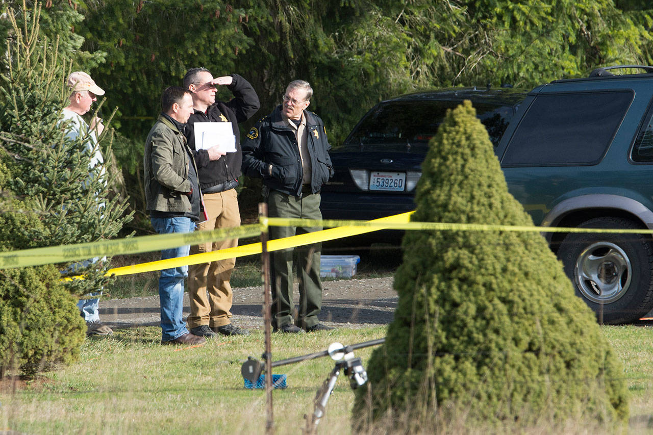 Clallam County Prosecuting Attorney Mark Nichols, left, talks with Clallam County Sheriff Bill Benedict on Tuesday at the scene of several deaths. (Jesse Major/Peninsula Daily News)
