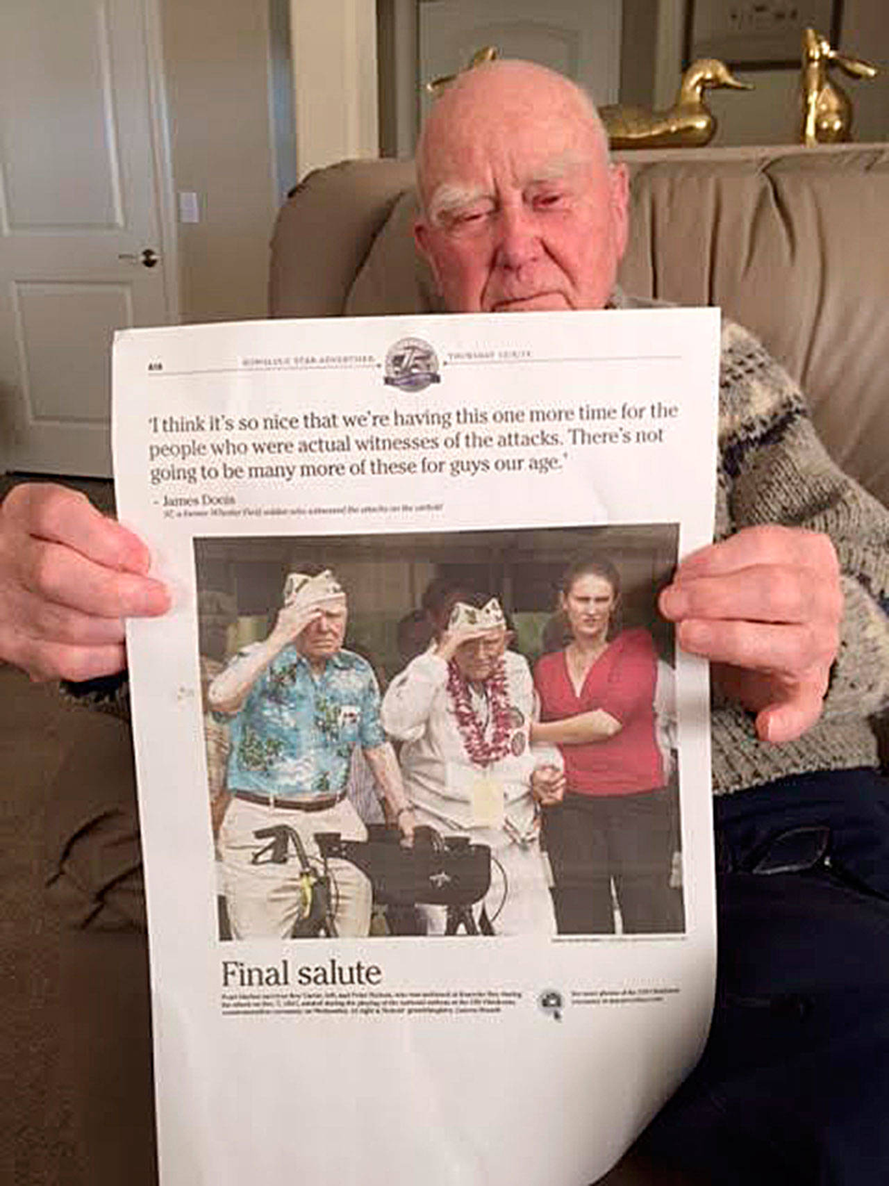Roy Carter of Sequim holds a copy of the Honolulu Star-Advertiser with a front page photo of him and another veteran of the attack on Pearl Harbor in 2017, soon after the 75th anniversary of the attacks. Carter died on Jan. 3 at age 98. (Mary Powell/file)