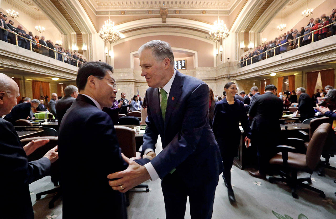 Gov. Jay Inslee greets a visitor following his State of the State address to a joint session of the Legislature on Tuesday in Olympia. (Elaine Thompson/The Associated Press)