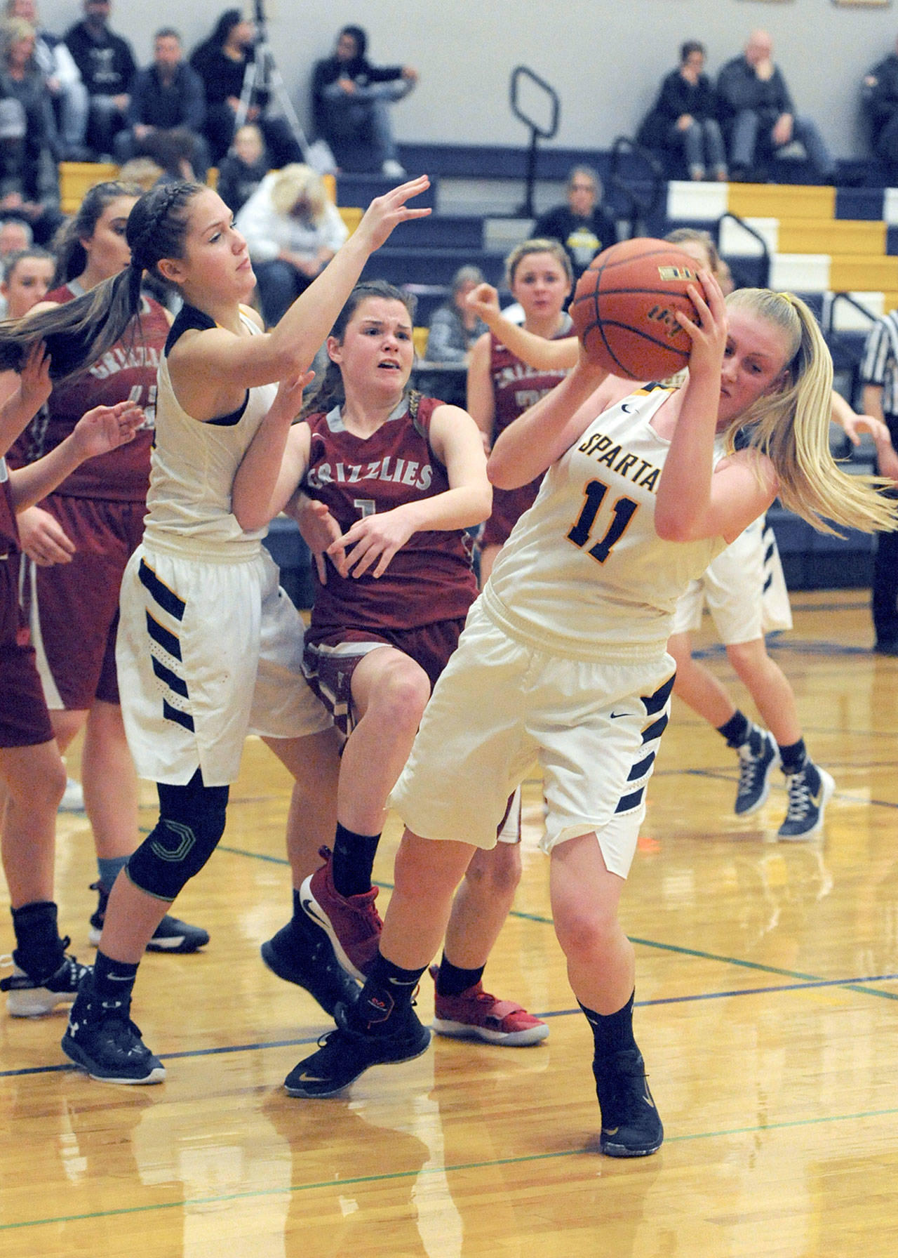 Lonnie Archibald/for Peninsula Daily News Forks’ Kesia Rowley, right, grabs the ball while defended by Hoquiam’s Jade Cox, center. Also in on the action is Forks’ Kray Horton, left.