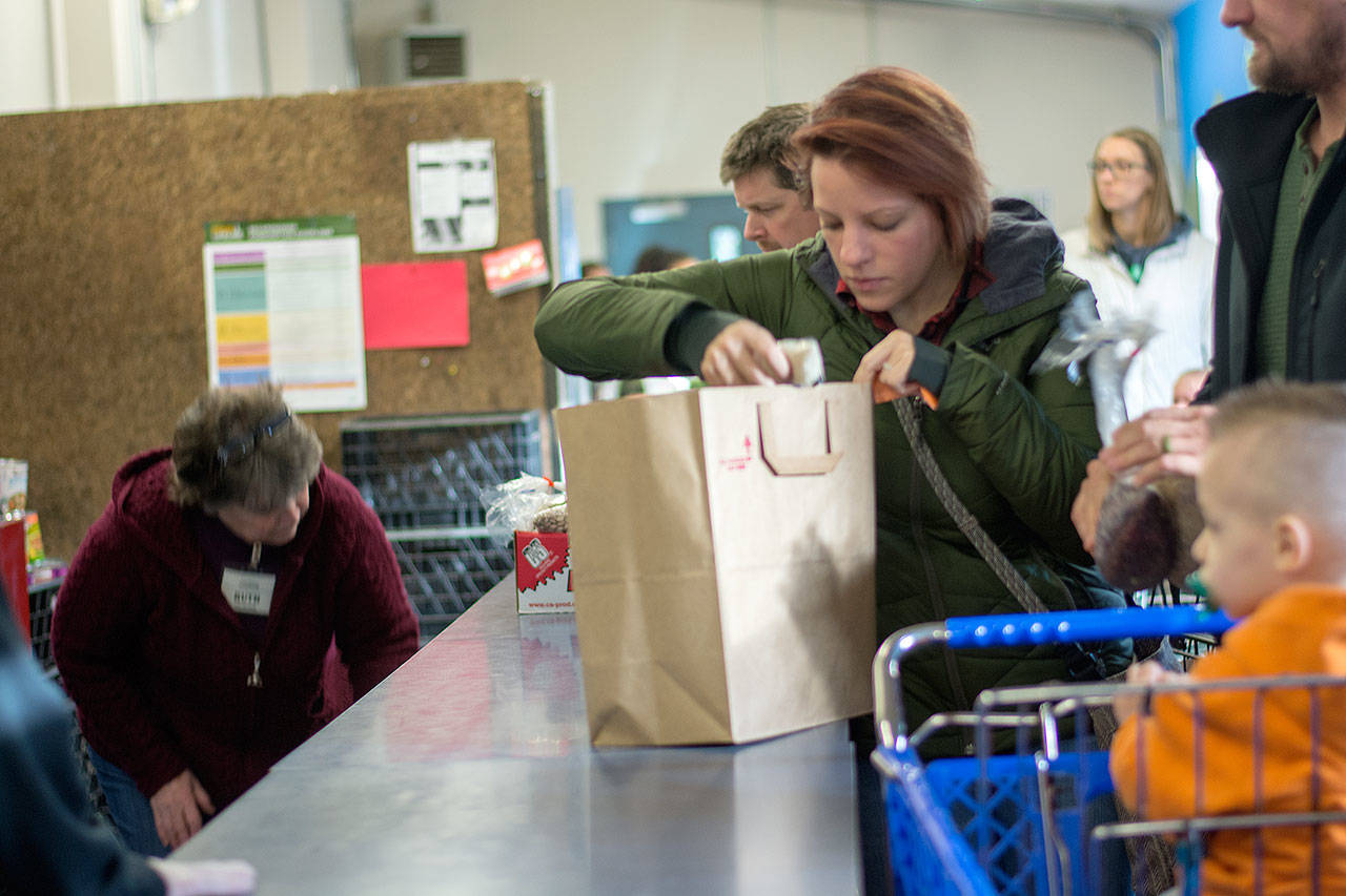 Ashley Gamble, whose husband serves in the U.S. Coast Guard, goes through the Port Angeles Food Bank during a special distribution for families of federal workers who have been affected by the government shutdown. (Jesse Major/Peninsula Daily News)