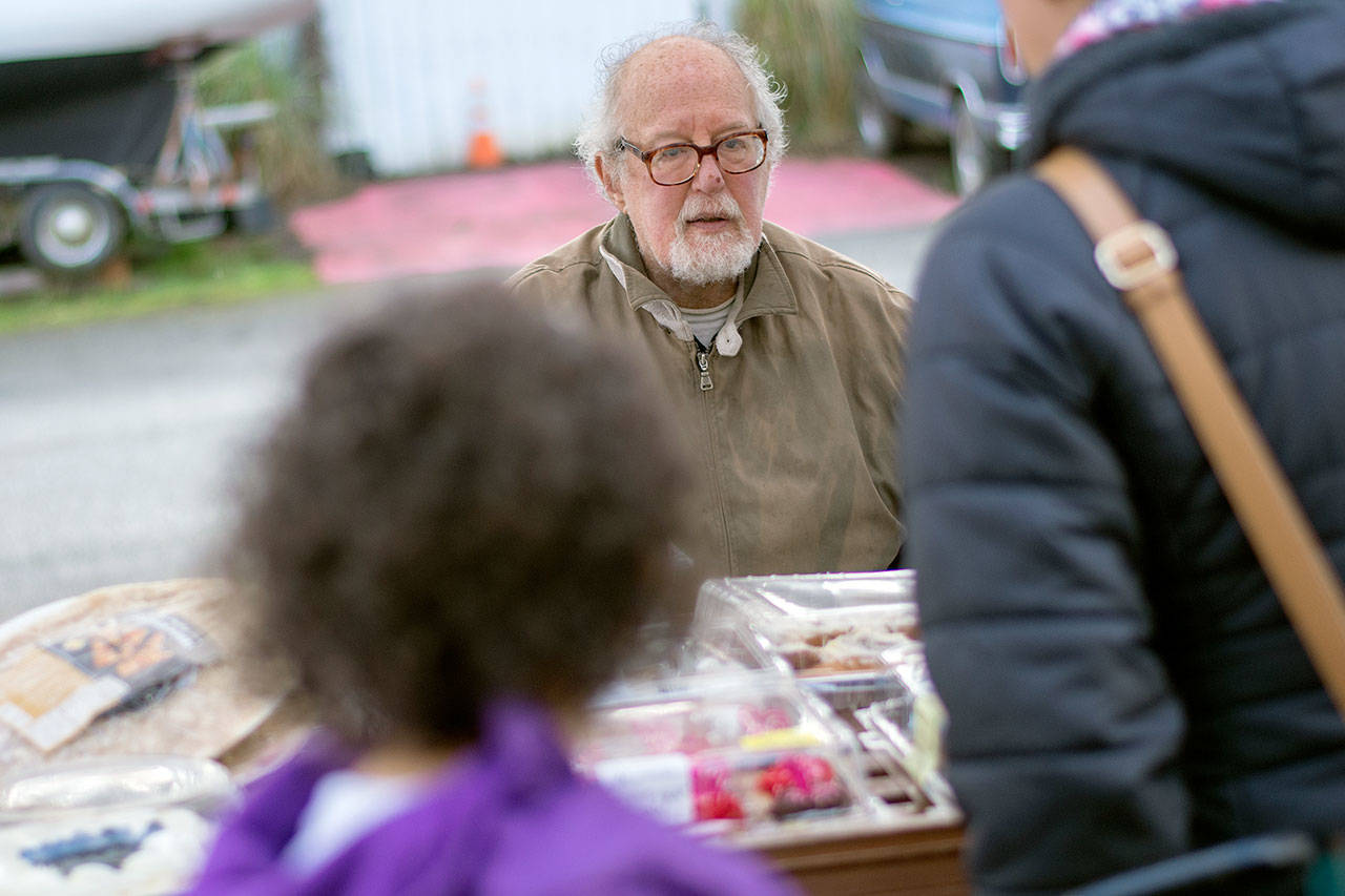 Jim Gluck, a volunteer at the Port Angeles Food Bank, offers desserts to a family during a special distribution Thursday for families of federal workers that have been affected by the government shutdown. (Jesse Major/Peninsula Daily News)
