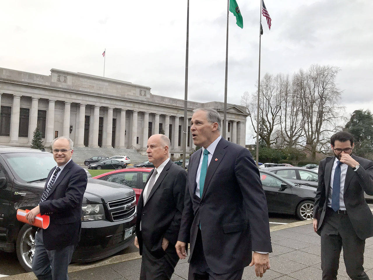 Former California governor Jerry Brown, middle left, and Gov. Jay Inslee, middle right, leave the Legislative Building in Olympia last Thursday. (Emma Scher/WNPA Olympia News Bureau)
