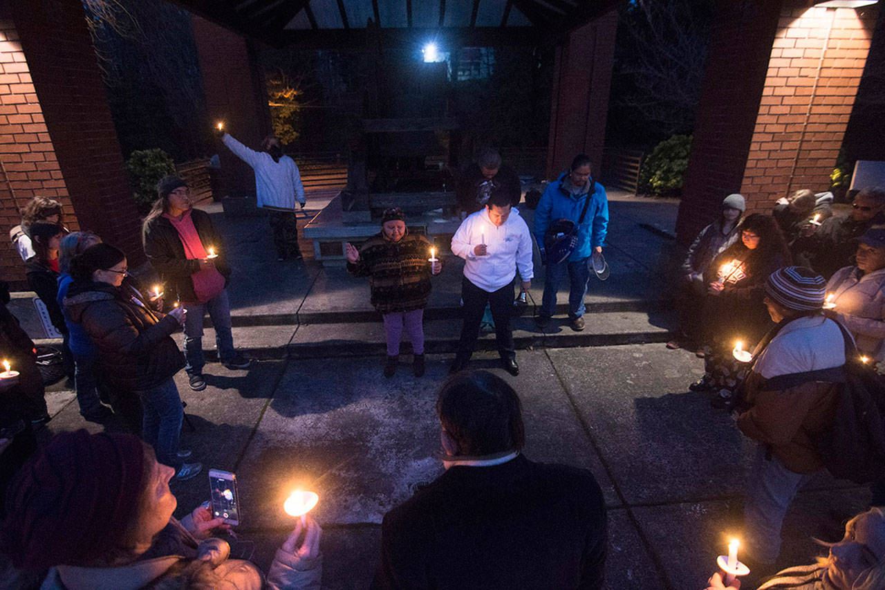 A crowd gathers around Thelma Lawrence and Jonathan Arakawa of the Lower Elwha Klallam Tribe as they sing during a vigil Monday evening for Valerie Claplanhoo, who was killed in Sequim on Jan. 2. (Jesse Major/Peninsula Daily News)