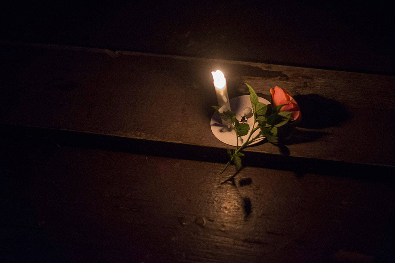 Candlelight illuminates a flower during Monday’s vigil for Valerie Claplanhoo, who was killed in Sequim on Jan. 2. (Jesse Major/Peninsula Daily News)
