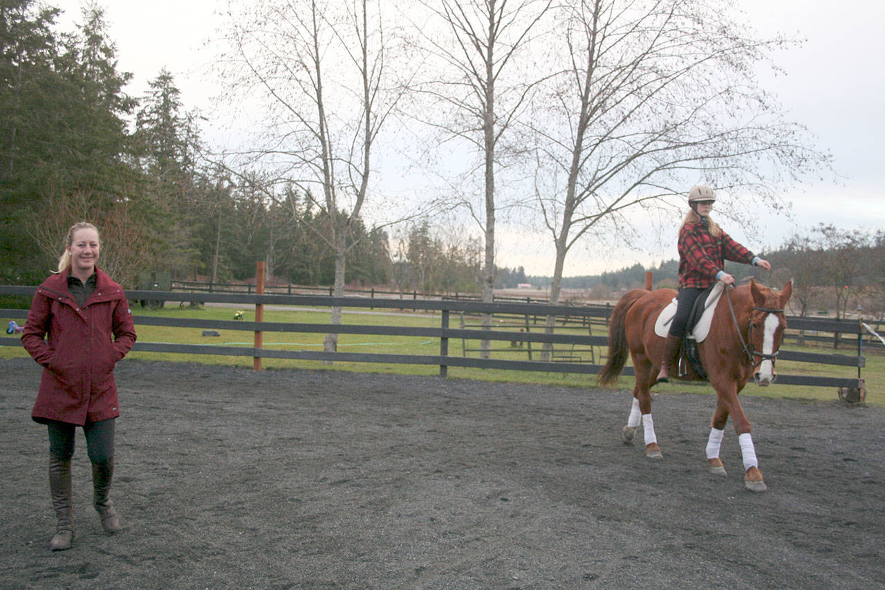 Port Townsend’s Heron Pond Farm Equestrian Center co-owner Christine Headley, left, gives a dressage lesson to 13-year-old Hazel Windstorm on Jude, a reliable schooling horse who is also well-versed in taking novice riders over jumps. Headley is currently the only United States Dressage Federation Certified Instructor in Jefferson County. (Karen Griffiths/for Peninsula Daily News)