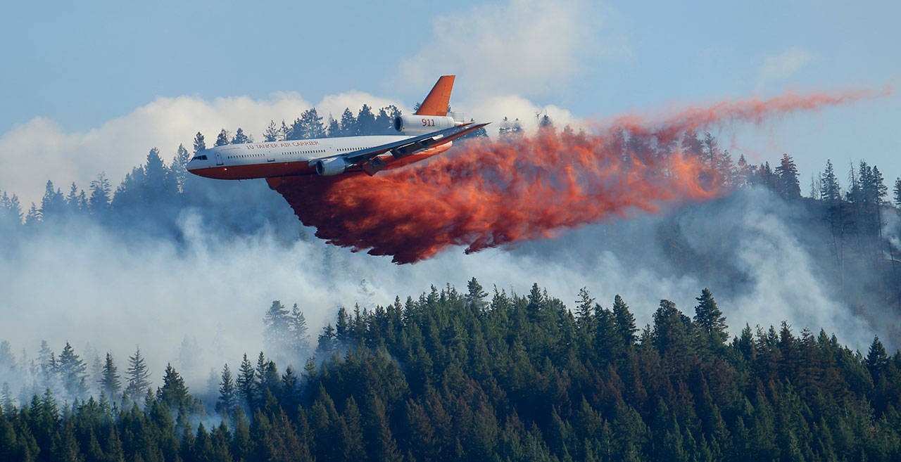 A tanker airplane drops fire retardant on a wildfire burning near Twisp. (Ted S. Warren/The Associated Press)