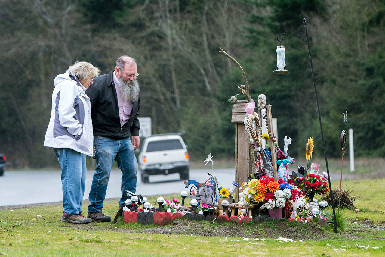Debra and Gary Johnson on Tuesday visit the roadside memorial for their gandaughter, Brooke Bedinger, who died in a motorcycle wreck on U.S. Highway 101 at Morse Creek on June 21. (Jesse Major/Peninsula Daily News)