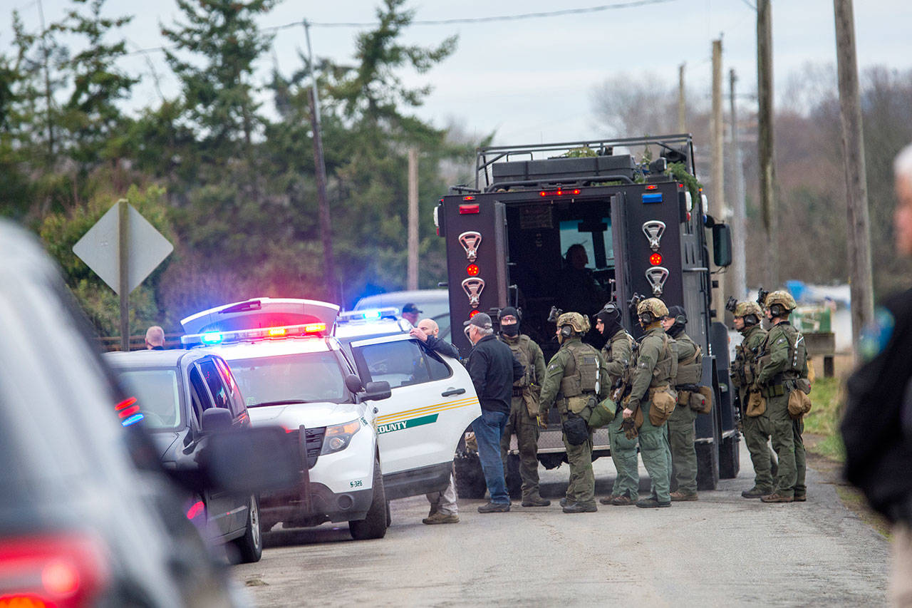 The State Patrol SWAT team gathers after serving a warrant Thursday morning that led to the arrest of a man suspected to be involved in the triple homicide discovered New Year’s Eve. (Jesse Major/Peninsula Daily News)