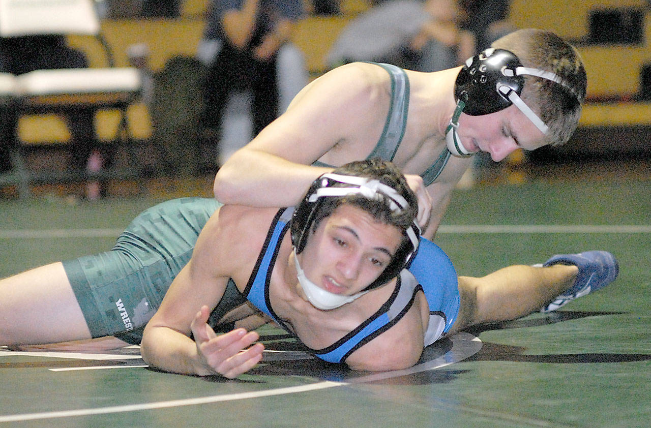 Keith Thorpe/Peninsula Daily News Port Angeles’ Daniel Basden, top, grapples with Olympic’s Robert Haugen in the 120 lb. weight class on Thursday at Port Angeles High School.