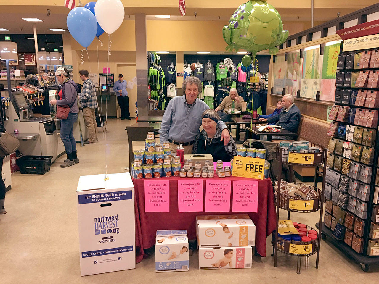 Herb Tracy and Kathy Ryan, volunteers for the Port Townsend Food Bank, man a donations table at the Safeway on 442 W Sims Way in Port Townsend on Friday.