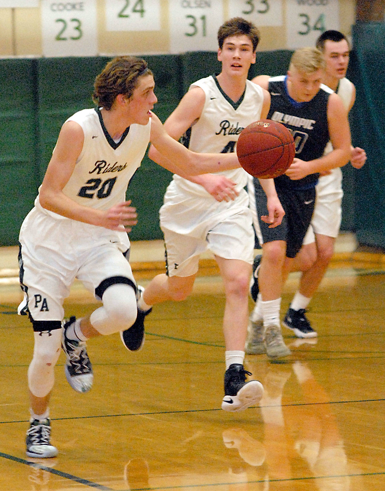 Keith Thorpe/Peninsula Daily News Port Angeles’ Payton Schmidt, left, grabs a loose ball and drives down court followed by teammates Gabriel Long and Liam Clark, right, and Olympic’s Greg Brehmer on Friday night at Port Angeles High School.
