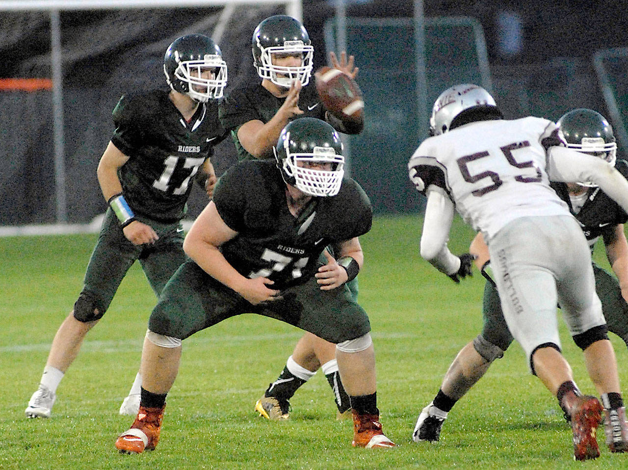 Keith Thorpe/Peninsula Daily News Port Angeles quarterback Brenden Roloson-Hines, center, takes the snap accompanied by teammates Garrett Edwards, left, and Cole Walsh as Montesano defensive lineman Kenny Koonrad defends during a game last September.