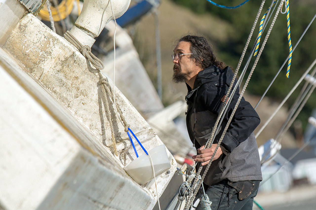 Tyler Vega, captain of the Ninaa Ootaki, climbs aboard the beached vessel Tuesday. She ran ashore at Beckett Point during a storm in December. (Jesse Major/Peninsula Daily News)