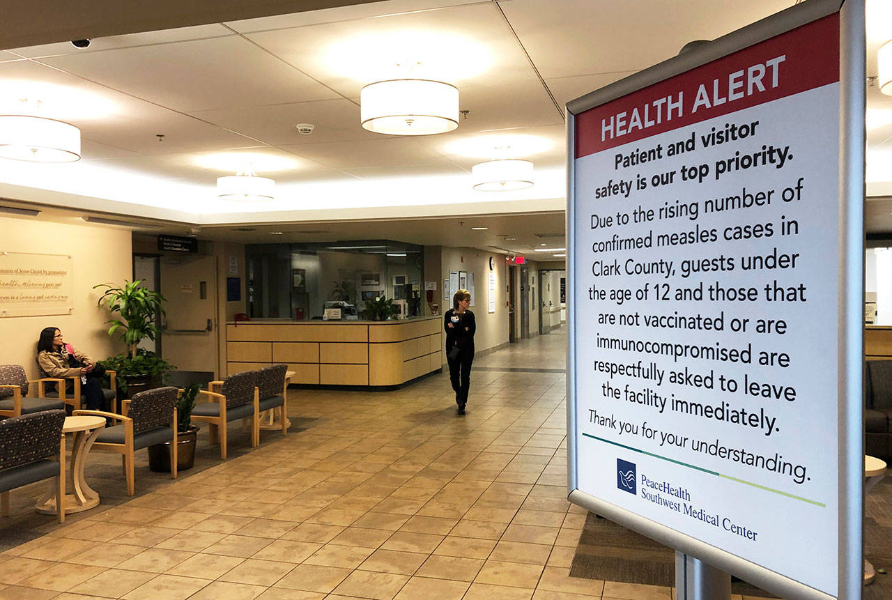 A sign prohibiting all children younger than 12 and unvaccinated adults stands Jan. 25 at the entrance to PeaceHealth Southwest Medical Center in Vancouver, Wash. (Gillian Flaccus/The Associated Press)