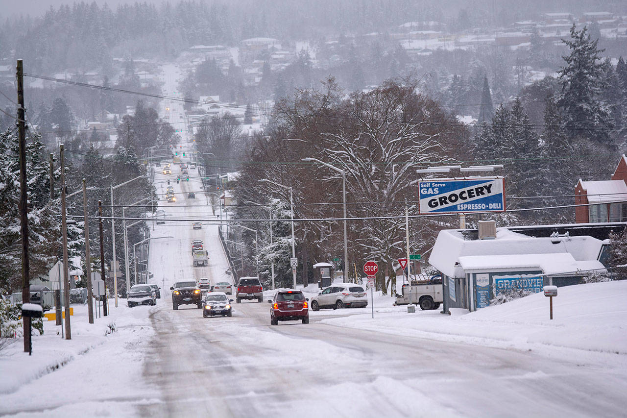 Traffic makes its way on Eighth Street in Port Angeles as snow continued to fall Monday morning. (Jesse Major/Peninsula Daily News)