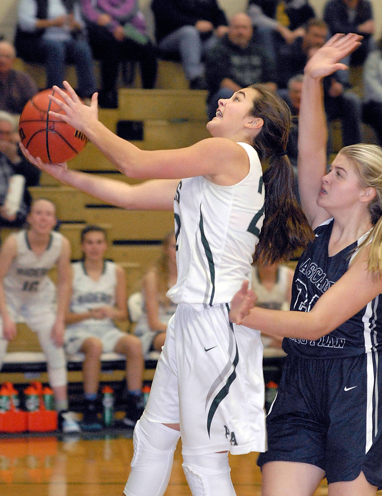 Keith Thorpe/Peninsula Daily News Port Angeles’ Eve Burke, left, goes for a layup while being defended by Cascade Christian’s Lexi Pearson during a game in December.