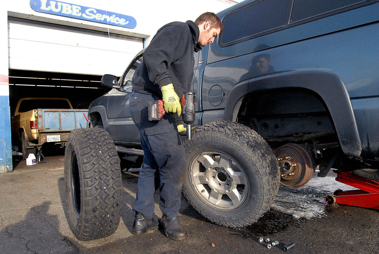 Jacob Lierly, a lubrication technician for Olympic Tire & Auto Repair in Port Angeles, prepares to install a set of snow tires on a customer’s truck Thursday. (Keith Thorpe/Peninsula Daily News)