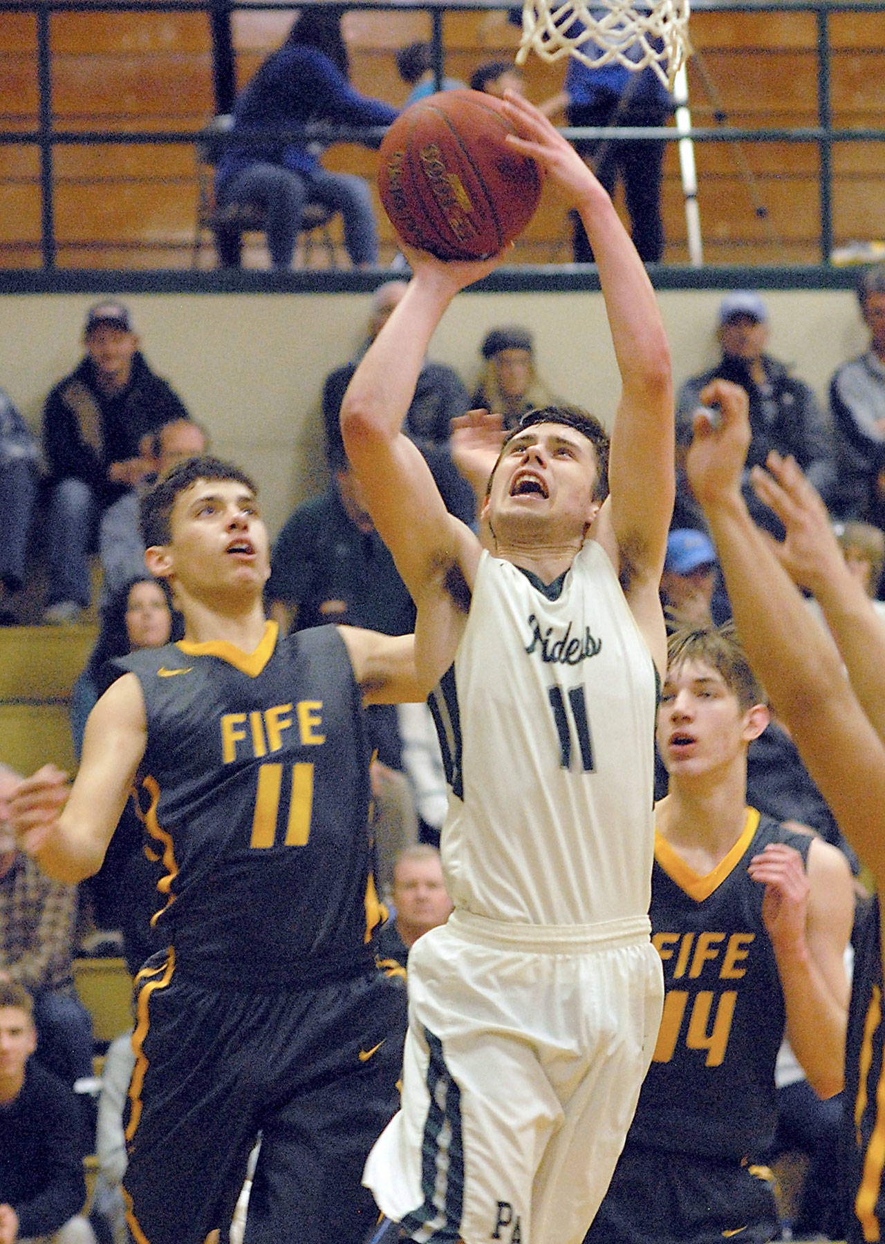 Keith Thorpe/Peninsula Daily News Port Angeles’ Kyle Benedict, center, goes for the basket over the defense of Fife’s Malachi Afework, left, during the second quarter on Thursday in Port Angeles.