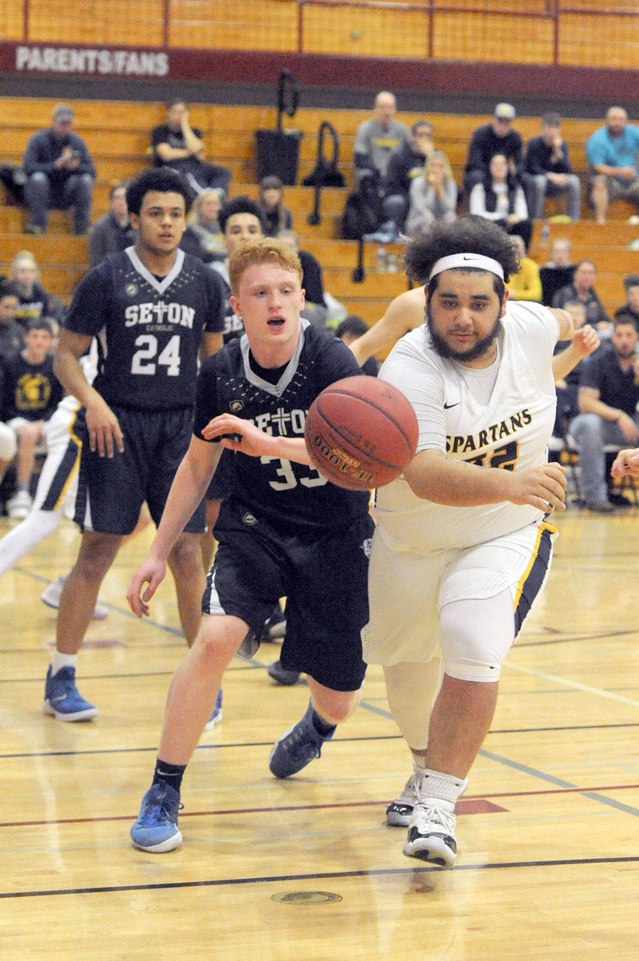 Spartan Iziah Morton (right) competes with Seton Catholic’s Andrew Olson (33) for ball control Thursday night in Chehalis during the 1A District 4 play-offs. Seton came back to defeat Forks 84 to 69 ending the Spartan’s season. Lonnie Archibald/for Peninsula Daily News