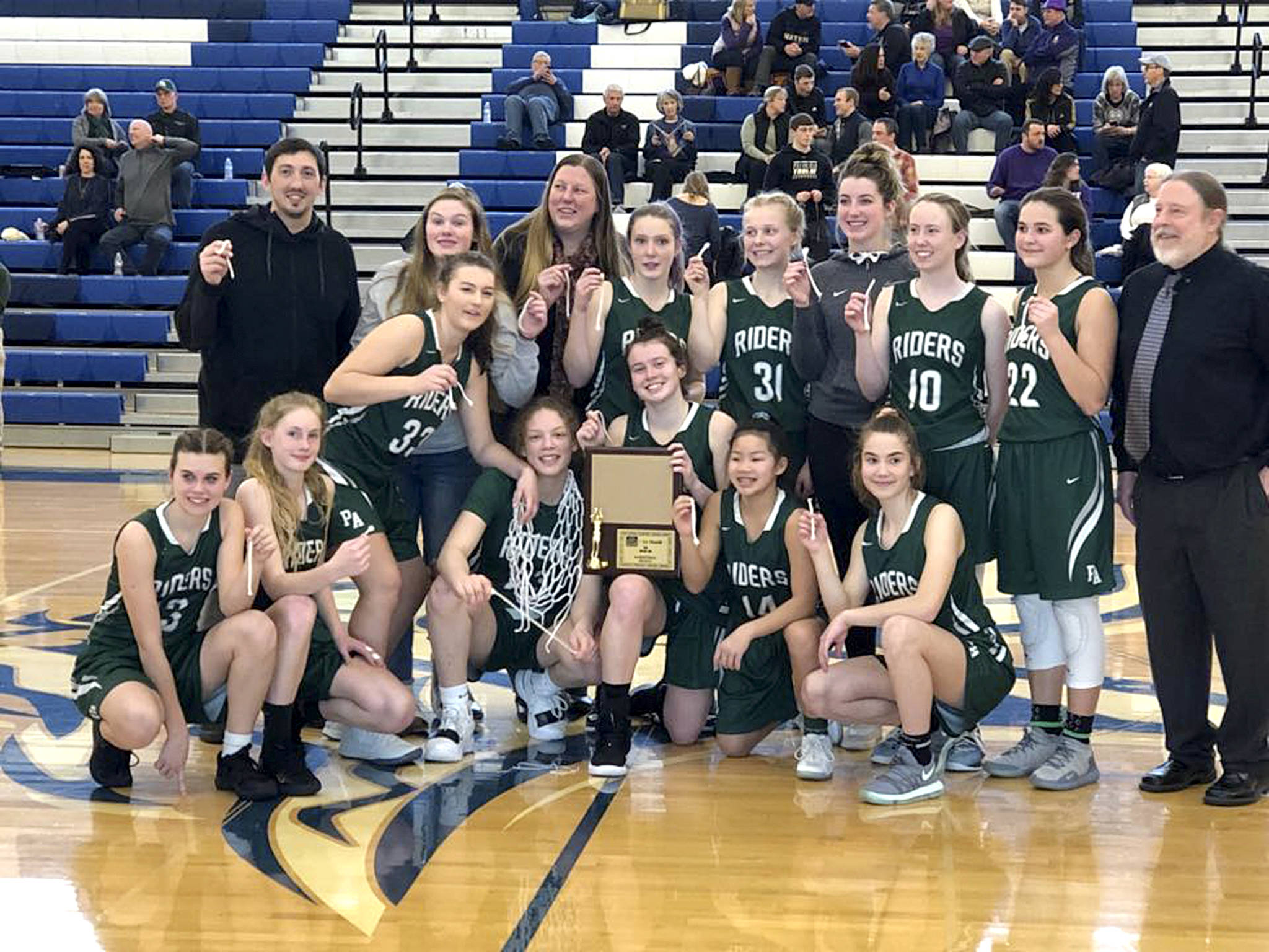The Port Angeles Roughriders girls basketball team Saturday celebrates winning the West Central District III 2A Tournament championship.
