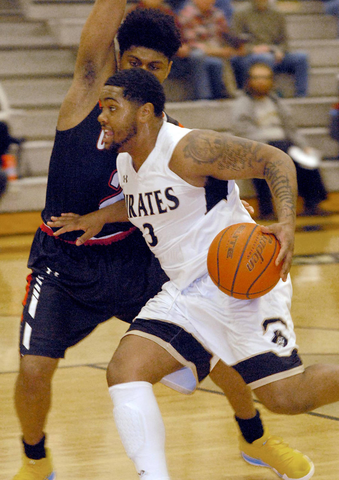 Keith Thorpe/Peninsula Daily News Peninsula’s Davien Harris-Williams drives past the defense of Olympic’s Will Johnson in the opening minutes of Friday night’s matchup in Port Angeles.