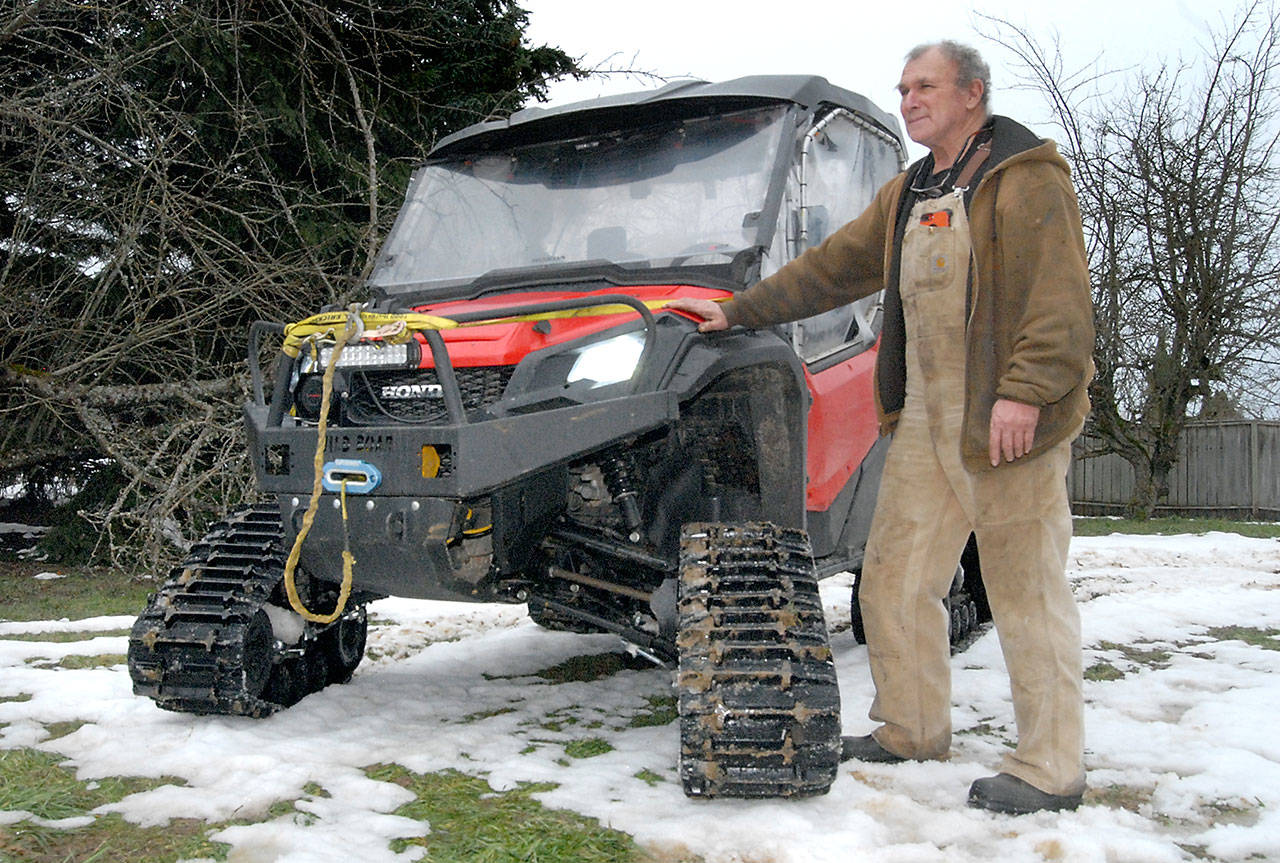 James Luna of rural Sequim stands next to his Honda Pioneer off-road vehicle that he uses to reach snowbound people in rural areas around Port Angeles and Sequim. (Keith Thorpe/Peninsula Daily News)