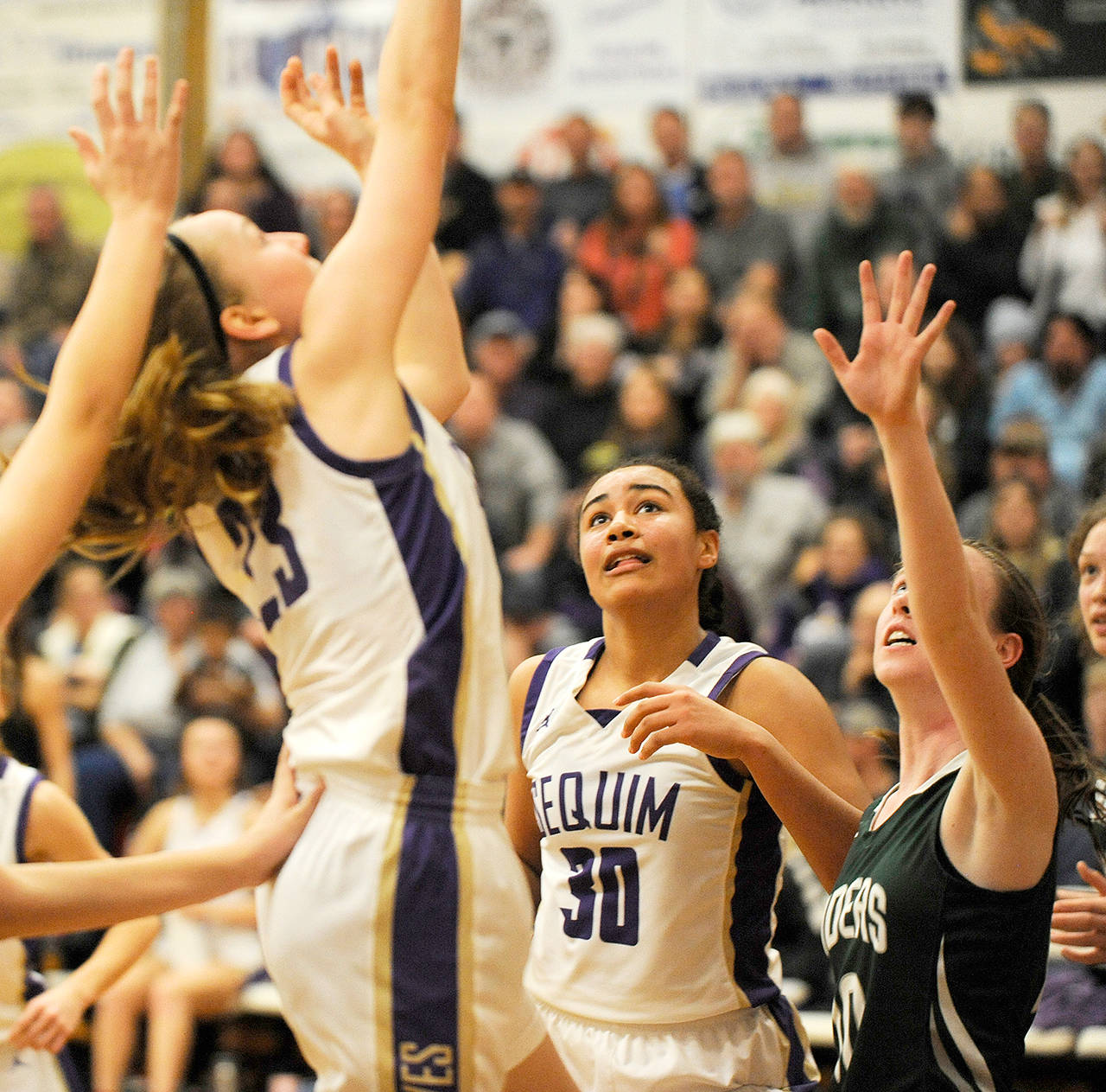 Michael Dashiell/Olympic Peninsula News Group Sequim’s Jayla Julmist, center, watches as teammate Kalli Wiker puts up a shot during a game against Port Angeles last month. Julmist is averaging a double-double this season, scoring 10 points and grabbing 14 rebounds per game.