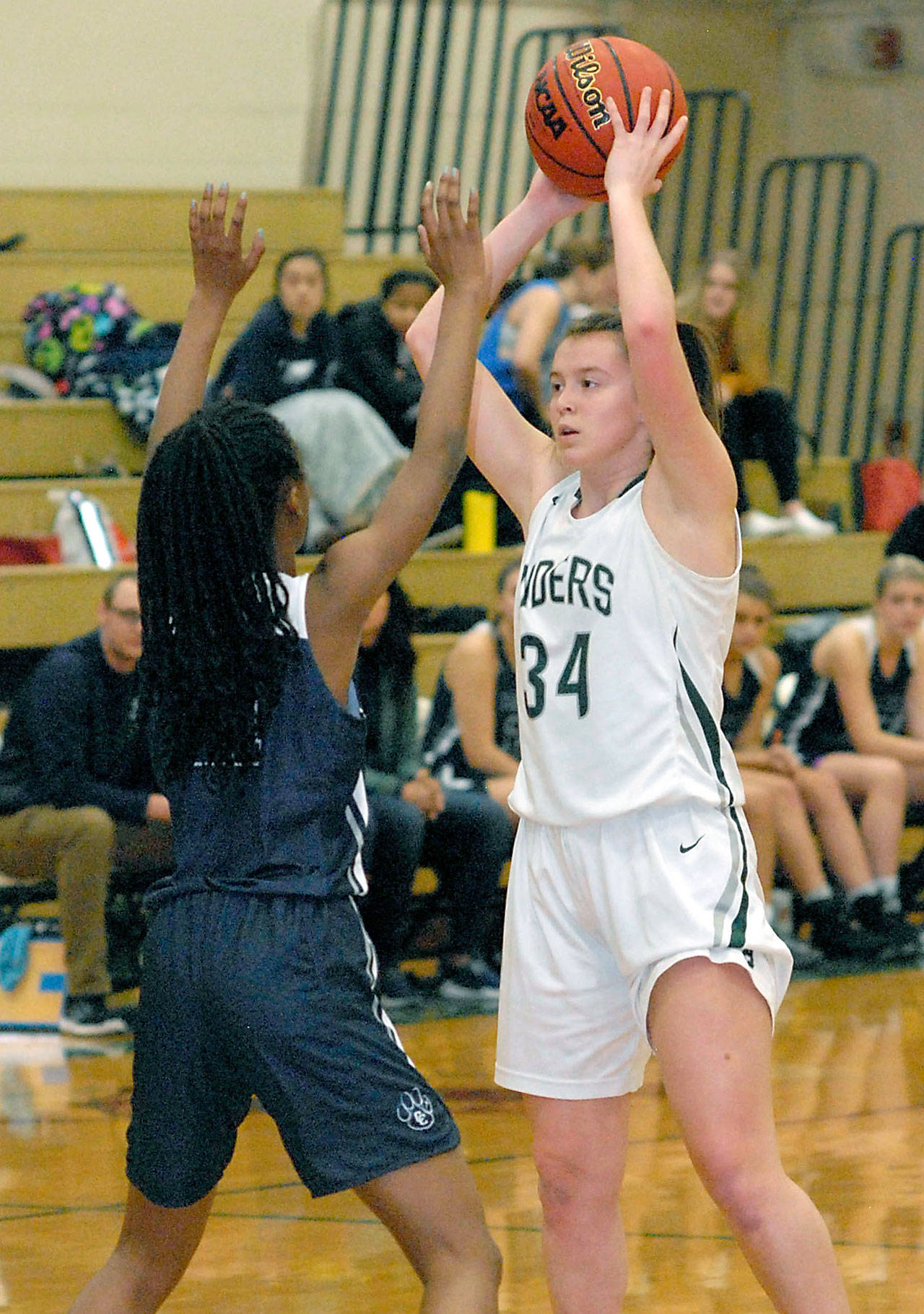 Keith Thorpe/Peninsula Daily News Port Angeles Jaida Wood, right, looks over the defense of Cascade Christians Anniah Smith in December.